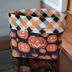 an orange and black basket with pumpkins on it