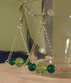 These gorgeous unique earrings have three Austrian crystal beads swinging from chains. The two outer ones are a deep green and the middle one is a light spring green. They dangle approximately 1-1/4 inches from the ear lobe and are hung from French style ear wires. They come with rubber earring backs to keep them securely in place. Green Dangling Bead Chandelier Earrings, Green Dangle Crystal Earrings, Green Metal Beaded Party Earrings, Green Metal Beaded Earrings For Party, Green Crystal Earrings For Jewelry Making, Green Chandelier Earrings For Party, Green Dangle Jewelry With Faceted Beads, Green Crystal Drop Earrings With Dangling Beads, Green Nickel Free Dangle Chandelier Earrings