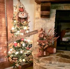 a decorated christmas tree in front of a fireplace with a snowman decoration on it