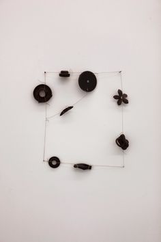 a clock made out of black objects on a white wall