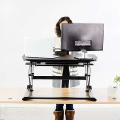 a woman sitting at a desk using a laptop computer