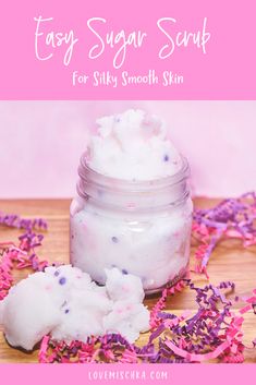 a jar filled with pink and purple sprinkles on top of a wooden table