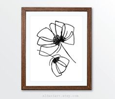 a black and white drawing of flowers in a wooden frame on the wall above it