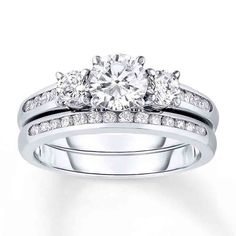 an engagement ring set with two round diamonds on the side and one diamond in the middle