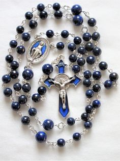 This lapis lazuli rosary can also be worn as a necklace. The body is about 27 inches and the cross extension is 6 inches. The blue enameled cross and connection were made in Italy and are oxidized silver. I used 6mm and 8mm lapis rounds and hand turned each of the wires myself. The crucifix is 1 and 3/4 inches long. This rosary will be slipped into an organza bag and shipped in a bubble mailer. Blue Spiritual Rosary With Gemstone Beads, Blue Gemstone Beads Rosary For Spiritual Use, Spiritual Blue Rosary With Gemstone Beads, Blue Crucifix Necklace For Spiritual Wear, Blue Crucifix Necklace For Spiritual Purposes, Adjustable Blue Rosary With Miraculous Medal, Handmade Blue Crucifix Jewelry, Blue Rosary With 8mm Beads And Crucifix, Blue Rosary With 8mm Beads In Cross Shape