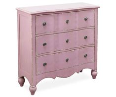 a pink chest of drawers sitting on top of a white floor