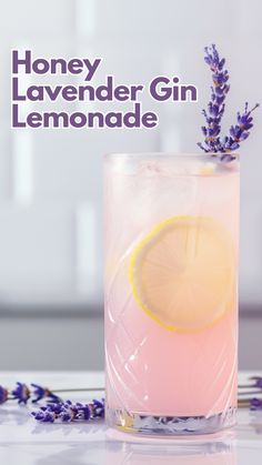 a pink lemonade drink with lavender sprigs on the rim and text honey lavender gin lemonade