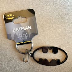 a batman key chain with a batman logo on it's front and back side