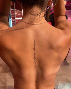 the back of a woman's upper body with her tattoo on top of it