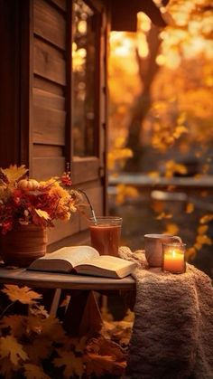 an open book sitting on top of a table next to a candle