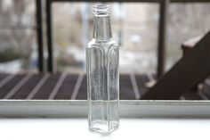 a glass bottle sitting on top of a window sill