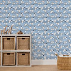 a blue wallpaper with white birds on it in a child's room next to baskets