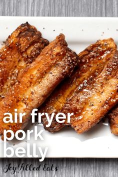 grilled pork pieces on a white plate with the words air fryer pork belly