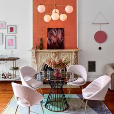 a dining room table with four chairs and a vase filled with flowers on top of it