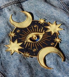 an eye and stars are on the back of a jean jacket with blue denim fabric