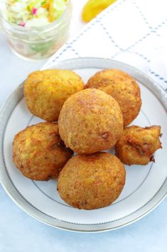 some fried food on a white plate next to a bowl