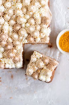 two pieces of cake with white frosting and sprinkles next to it