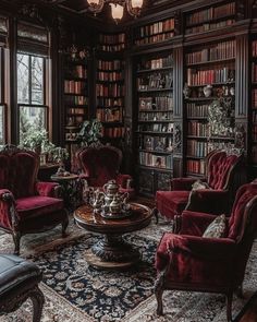 a living room filled with lots of red furniture and bookshelves full of books