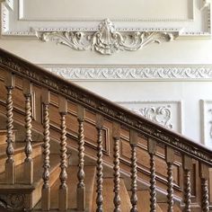 an ornate staircase with wooden handrails and white walls