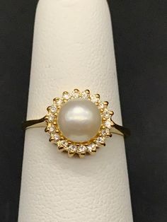 a close up of a ring on a white napkin with a diamond and pearl center