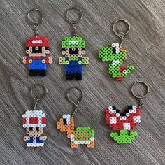 four pixel keychains with mario and luigi on them, all made out of perler beads