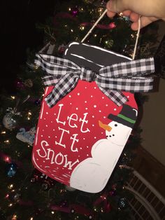 a christmas ornament that says let it snow with a snowman on it