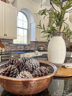 a bowl filled with pine cones on top of a kitchen counter