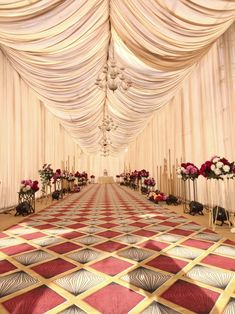 an elaborately decorated hall with red and white flowers on the floor in front of it