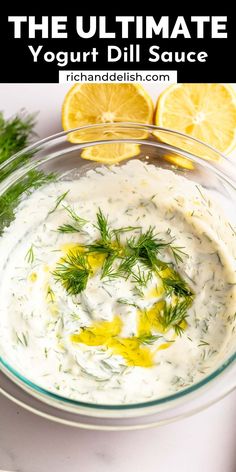 the ultimate yogurt dill sauce in a glass bowl with lemons and parsley