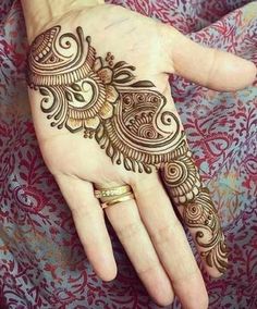 a woman's hand with henna tattoos on it