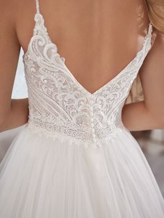 the back of a woman's wedding dress, with white lace and tulle