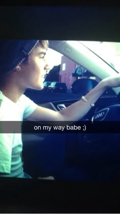 a person sitting in a car with the words on my way babe