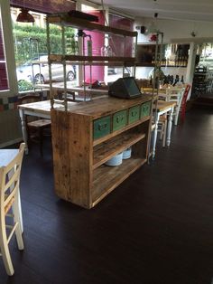 the inside of a restaurant with tables, chairs and an open shelf on one side