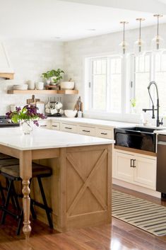 a kitchen with an island, sink and dishwasher next to a stove top oven