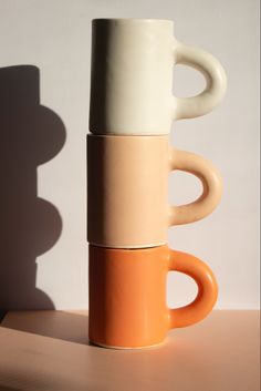 Stack of 3 handbuilt mugs in white, peach, and papaya colours. Mug Stacking, Handbuilt Mug, Coil Ceramics, Handbuilt Ceramics, Handmade Ceramic Mugs, Marshmallow Mugs, Pottery Handbuilding, Pottery Inspiration, Porcelain Mugs