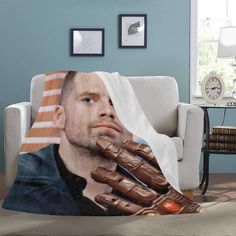 a blanket with a photo of a man holding his hand out to the side, in front of a blue wall