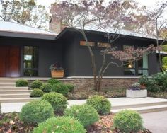 a house that is very nice and has some plants in the front yard, along with steps leading up to it