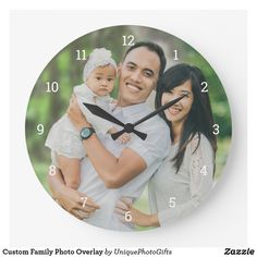 a man and woman holding a baby in their arms on a wall clock with the time