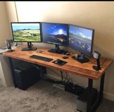 two computer monitors sitting on top of a wooden desk