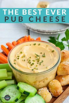 the best ever pub cheese dip recipe is on a platter with cucumbers, carrots and celery