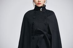 "How gorgeous is this elegant black cape with stand up collar and ruffle details. It's enough to keep you warm but keeping your hands available when needed as a winter cape, but also a perfect option when pregnant. Made from soft wool fabric, the short cape is completely lined in polyester with a tie belt waist, pockets. This is a cape coat you will wear forever. DESIGN FEATURES * 50% Wool blend, 50% fiber nylon * Polyester lining * Double Breasted * Seam pockets * Stand up collar with ruffles * Black Cape With Cape Sleeves For Work, Chic Black Cape With Cape Sleeves, Winter Evening Capelet, Elegant Black Cape Outerwear, Chic Black Capelet, Elegant Winter Capelet, Chic Winter Capelet, Black Cape For Evening Wear, Elegant Evening Winter Capelet