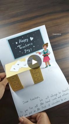 someone is holding up a card with an image of a teacher's desk on it