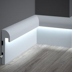 a corner bench with lights on it in the middle of an empty room and wood flooring