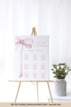 an easel with a wedding seating plan on it and a potted plant next to it