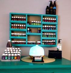 a green table topped with lots of bottles next to a shelf filled with other items