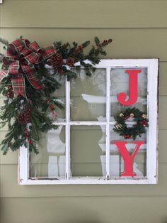 a window decorated with christmas wreaths and pine cones