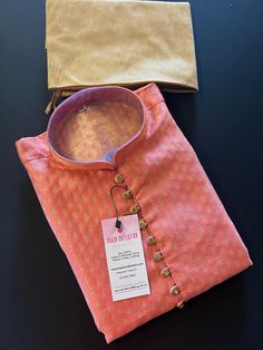 Premium quality Banarasi Silk Men's Kurta Pajama Set for Men with Woven Buttis all over the front and back of the Kurta with fancy buttons on the neckline. The Kurta does not have a lining. Item : Men's Kurta PajamaReady to Wear : YesKurta Color : Peachy PinkPajama Color : Gold Pocket : YesFabric : Banarasi Silk (Non Pure Silk)Work : Fancy buttons, Woven Zari workPattern : DesignerLining : No Pink Kurti, Sherwani For Men Wedding, Mens Wear Wedding, Red Kurta, Kurta Men, Men's Kurta, Mens Kurta Designs, Kurta Pyjama, Kurta Design