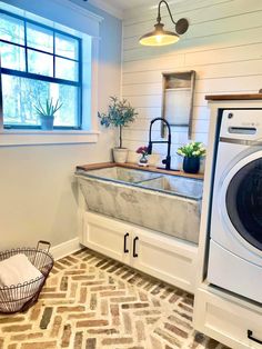 a washer and dryer in a laundry room with a window over the sink