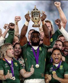 the rugby players are holding up their trophy