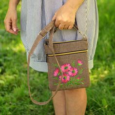 a woman is holding a purse with flowers on it